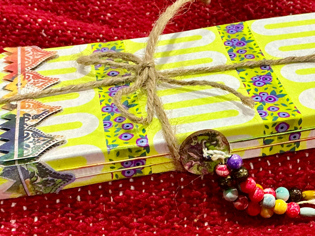 Close up of spine with colorful button and three strings of multi colored beads.