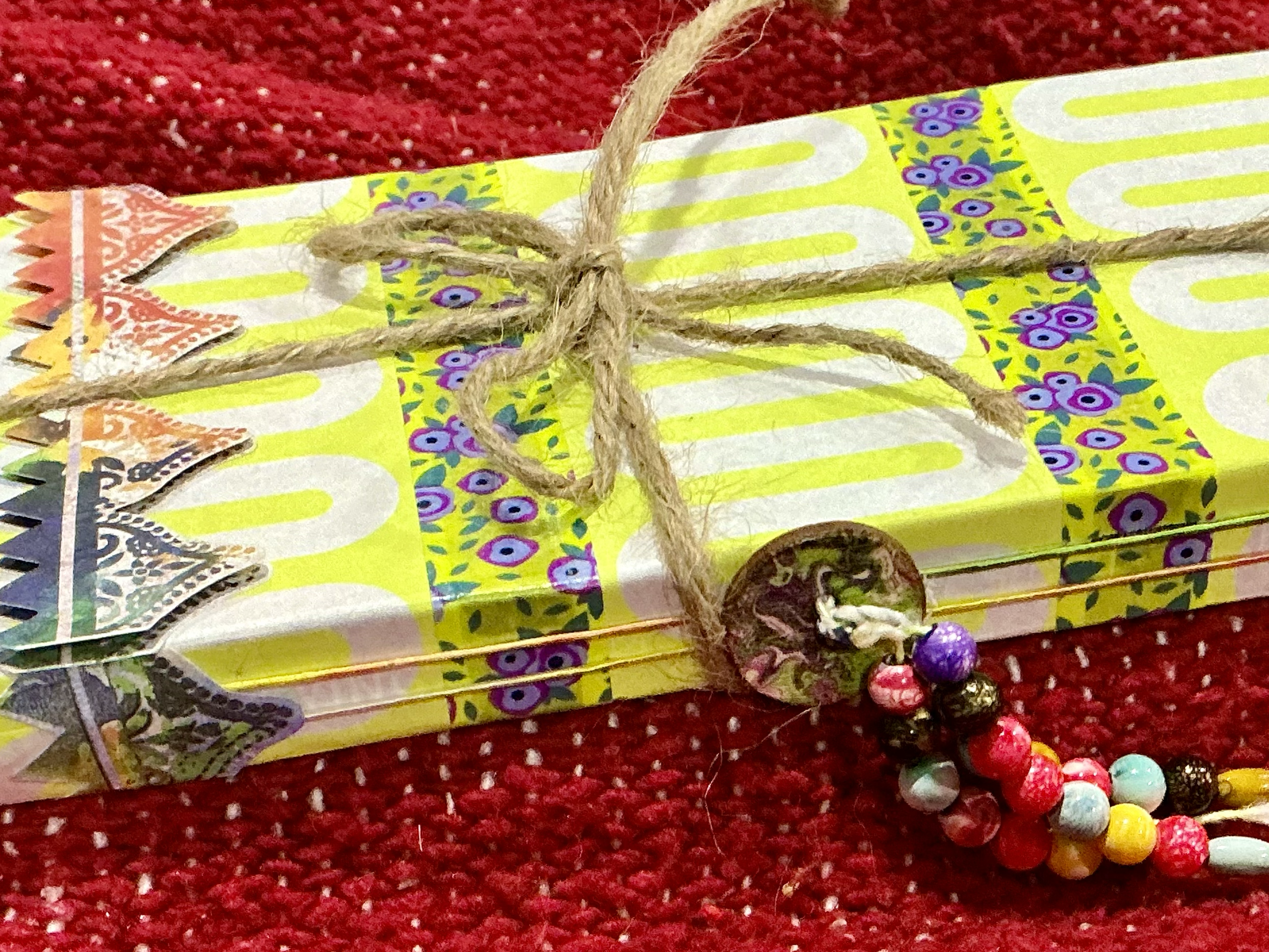 Close up of spine with colorful button and three strings of multi colored beads.